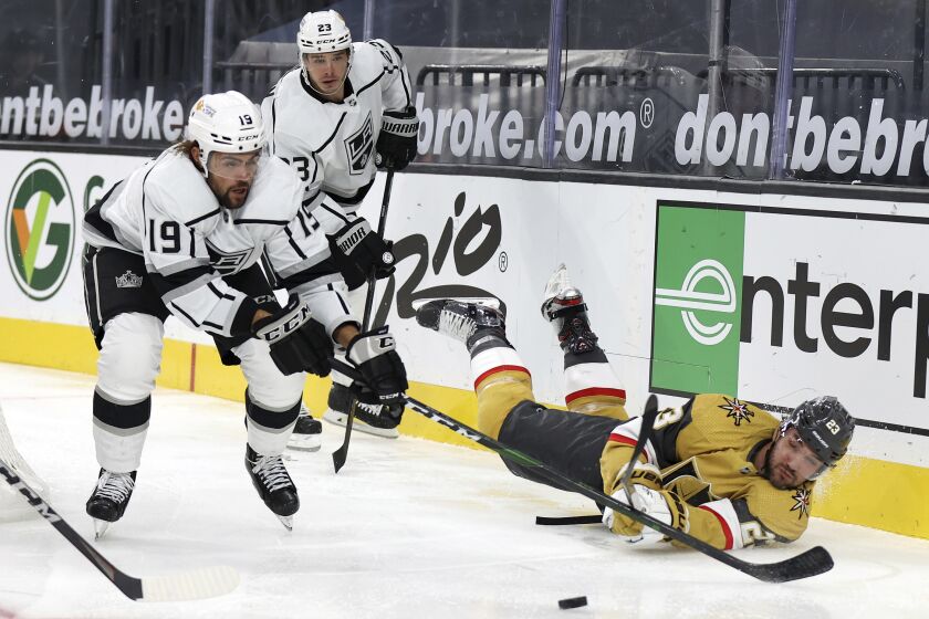 Vegas Golden Knights defenseman Alec Martinez, right, and Los Angeles Kings center Alex Iafallo, left, fight for control of the puck during the third period of an NHL hockey game Sunday, Feb. 7, 2021, in Las Vegas. (AP Photo/Isaac Brekken)