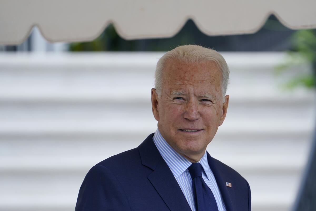 President Biden in a suit in front of white stairs