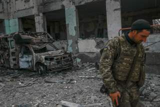 A Ukranien soldier stands outside a school hit by Russian rockets in the southern Ukraine village of Zelenyi Hai between Kherson and Mykolaiv, less than 5km from the front line on April 1, 2022, as NATO says it is not seeing a pull-back of Russian forces in Ukraine and expects "additional offensive actions", alliance chief warns. (Photo by BULENT KILIC / AFP) (Photo by BULENT KILIC/AFP via Getty Images)