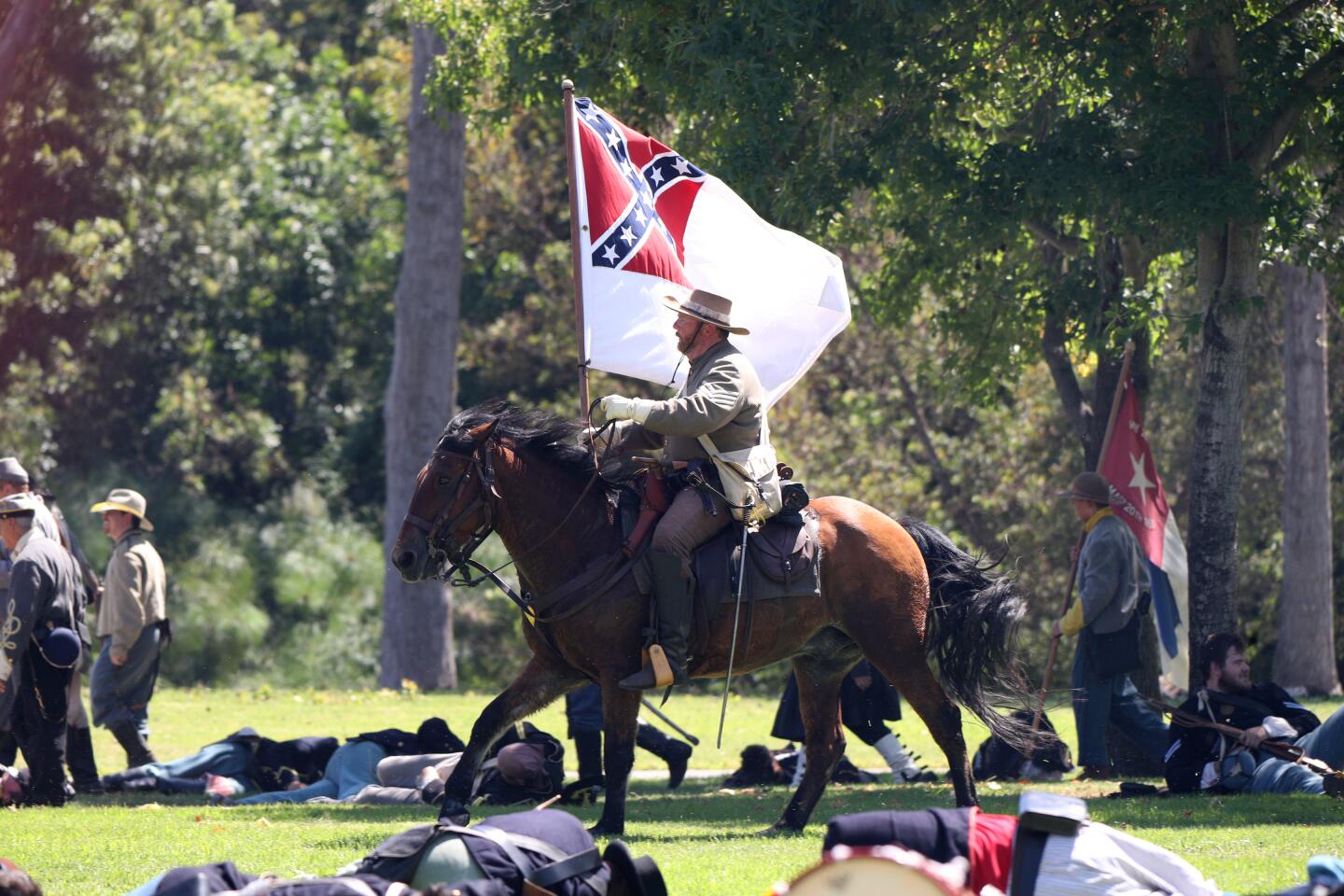 A rebel rider carries their flag into battle at the Huntington Beach Historical Society's Civil War Reenactment at Central Park, in Huntington Beach on Saturday, Aug. 31, 2019. It's the 26th annual Civil War Days Living History Event at the park.