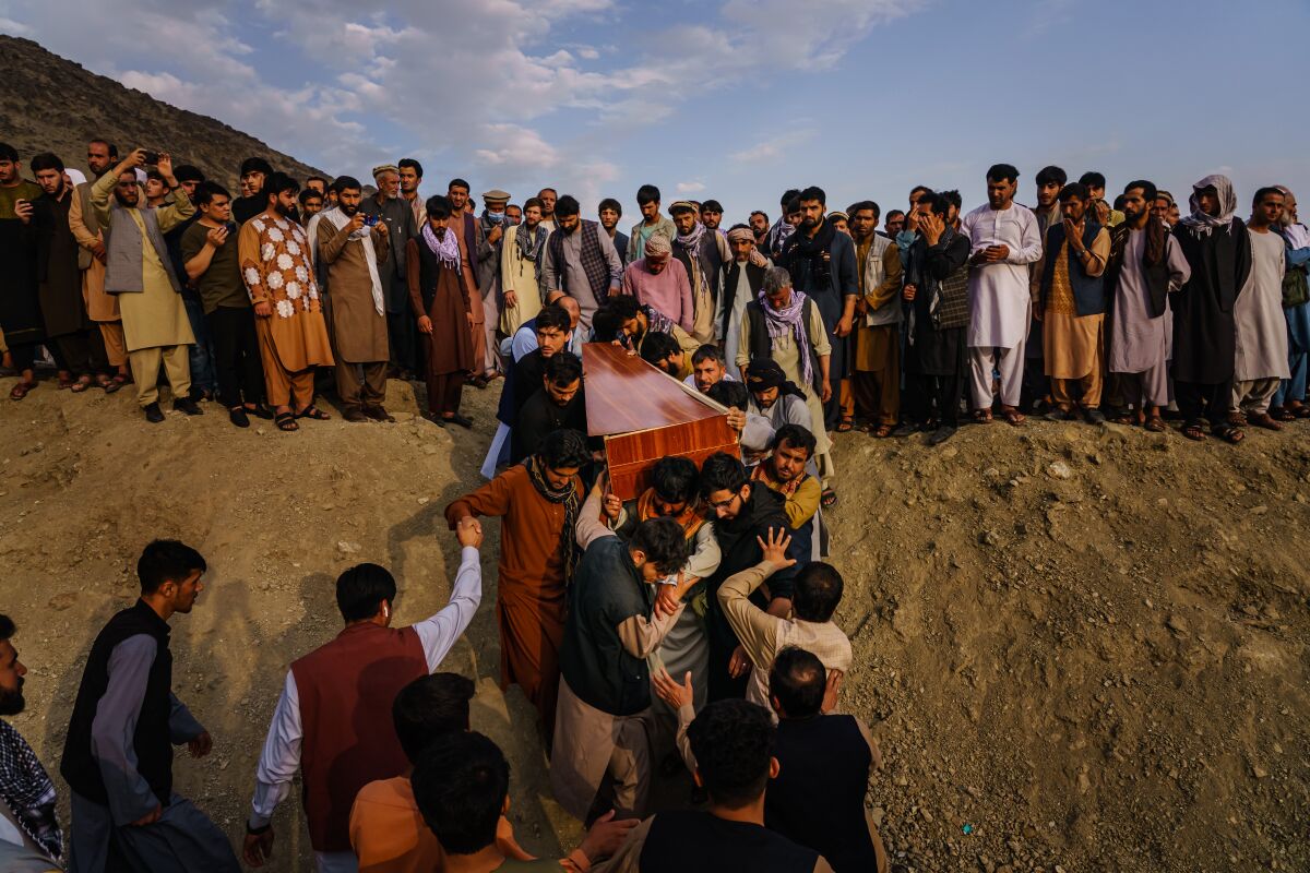 Caskets are carried toward a gravesite