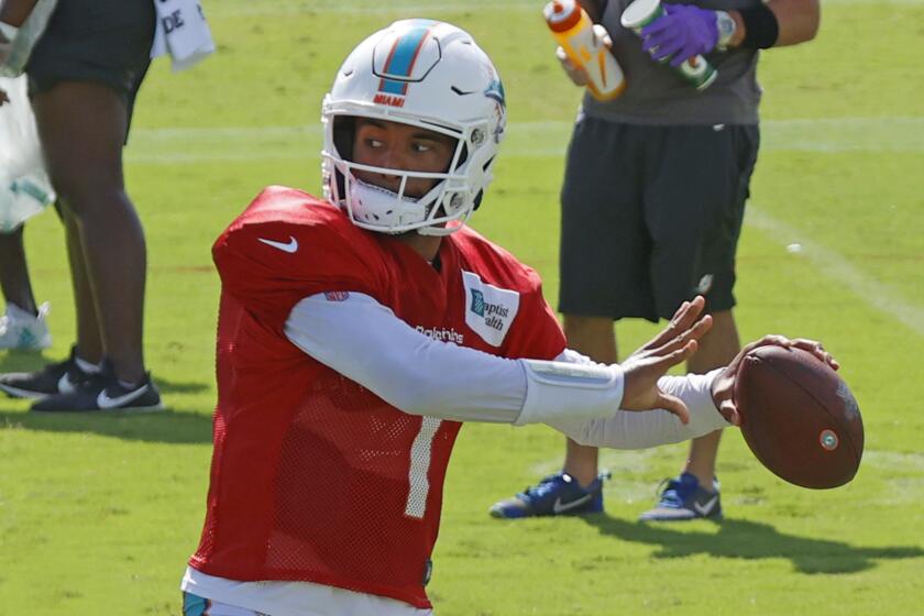 FILE - In this Aug. 18, 2020, file photo, Miami Dolphins quarterback Tua Tagovailoa (1) throws the ball during an NFL football training camp practice in Davie, Fla. If Brian Flores is to become the Miami Dolphins’ first Super Bowl coach since Don Shula, he needs for Tua Tagovailoa to become their best quarterback since Dan Marino.(AP Photo/Joel Auerbach, File)