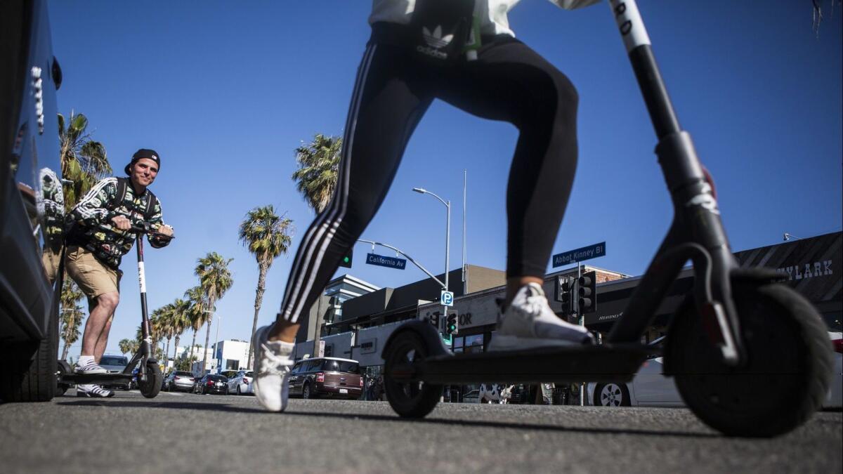 People ride Bird scooters in Venice in 2018.