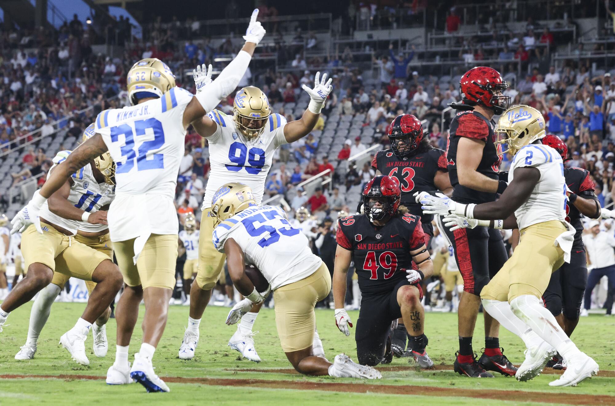 UCLA players celebrate an interception against San Diego State.