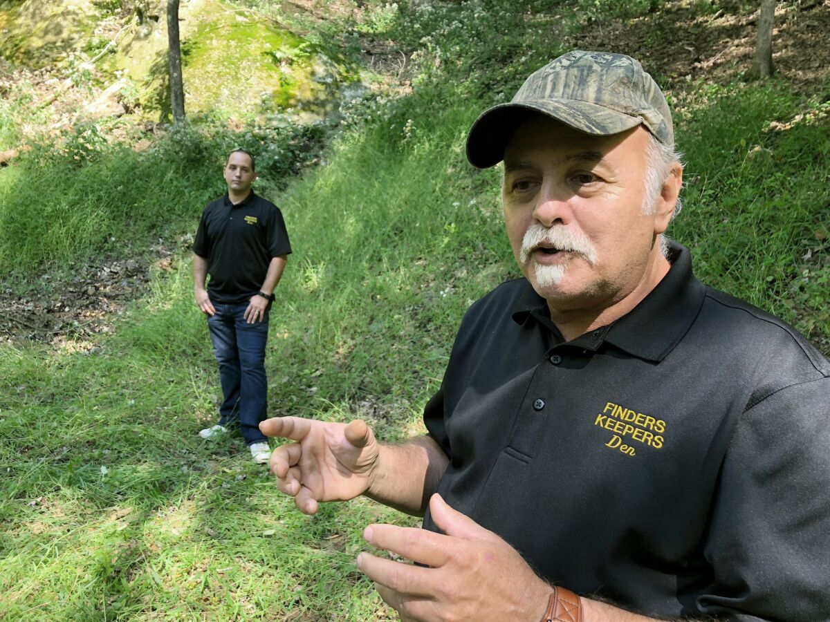 FILE-This Sept. 20, 2018 file photo, Dennis Parada, right, and his son Kem Parada stand at the site of the FBI's dig for Civil War-era gold in Dents Run, Pa. Government emails released under court order show that FBI agents were looking for gold when they excavated Dent's Run in 2018, though the FBI says that nothing was found. The treasure hunters have filed suit against the Justice Department over its failure to produce documents related to the FBI's 2018 search for Civil War-era gold at the remote woodland site. (AP Photo/Michael Rubinkam, File)