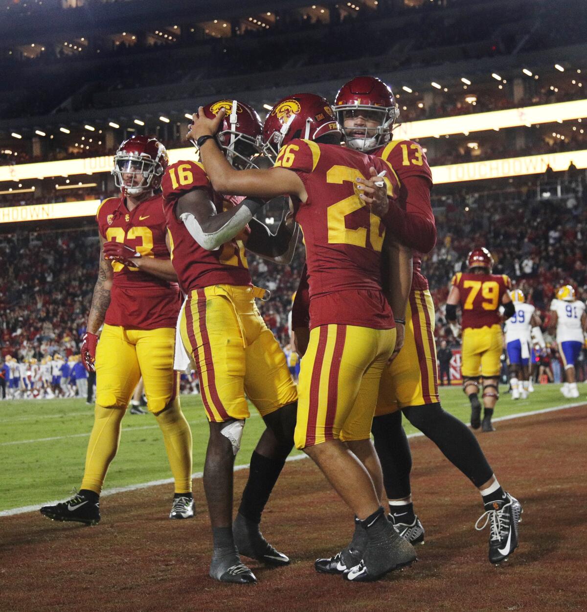 USC teammates congratulate running back Travis Dye (26) after he scored on a 12-yard run against California.