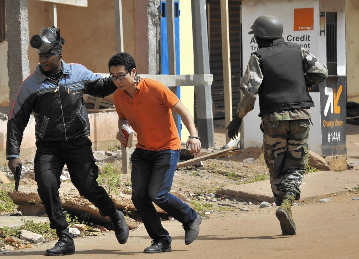 Malian security forces evacuate a man from the Radisson Blu hotel in Bamako during a siege that left dozens dead.