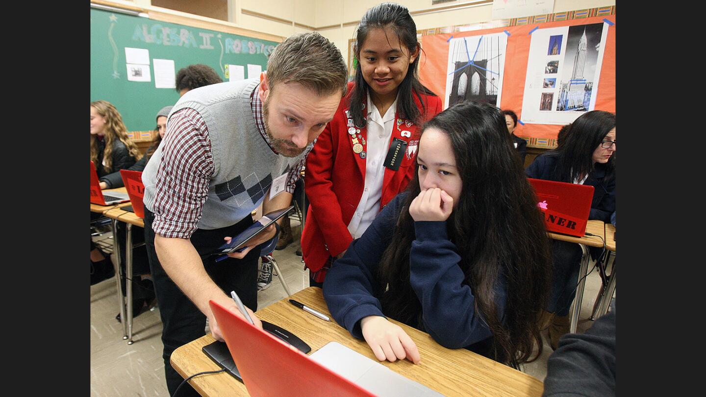 Math teacher Simone Butera, with help from student ambassador Shanley Galanto, 16, helps Haley Ansel, 14, of Clairbourn School in San Gabriel, get logged into her computer at Flintridge Sacred Heart Academy's first mid-school-year Academic Preview Night on Thursday, January 12, 2017. 200 people, including 8th graders and their families, visited to take part in 20 minute mini classes to get a taste of the academics available at the school.