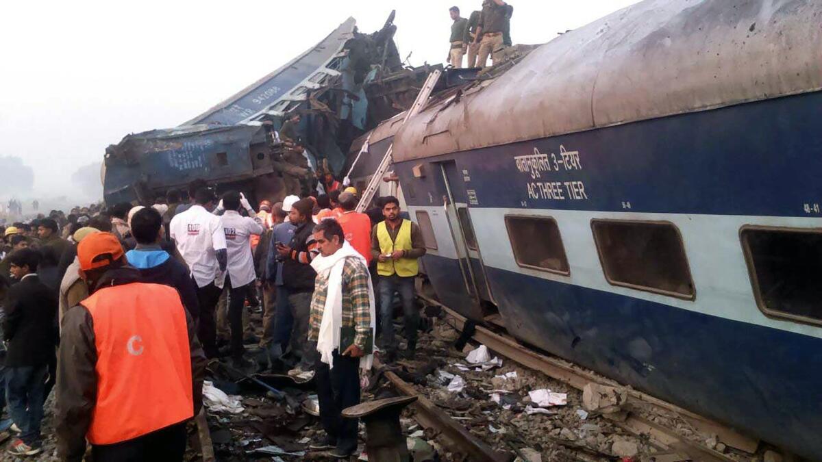 Rescue workers search derailed train cars near Pukhrayan, India.