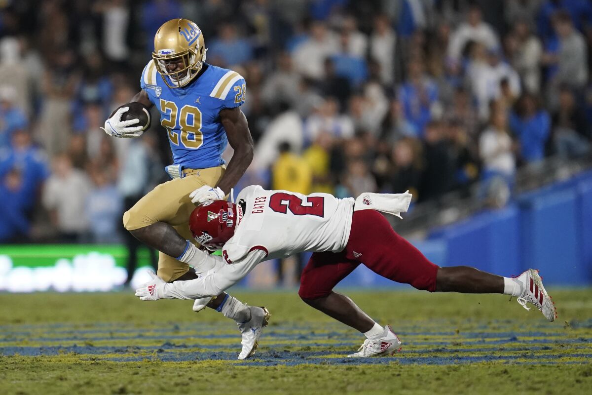 UCLA running back Brittain Brown runs past Fresno State defensive back Elijah Gates.