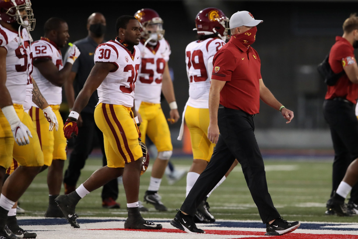 USC running back Markese Stepp and coach Clay Helton walk onto the field after a win over Arizona on Nov. 14.