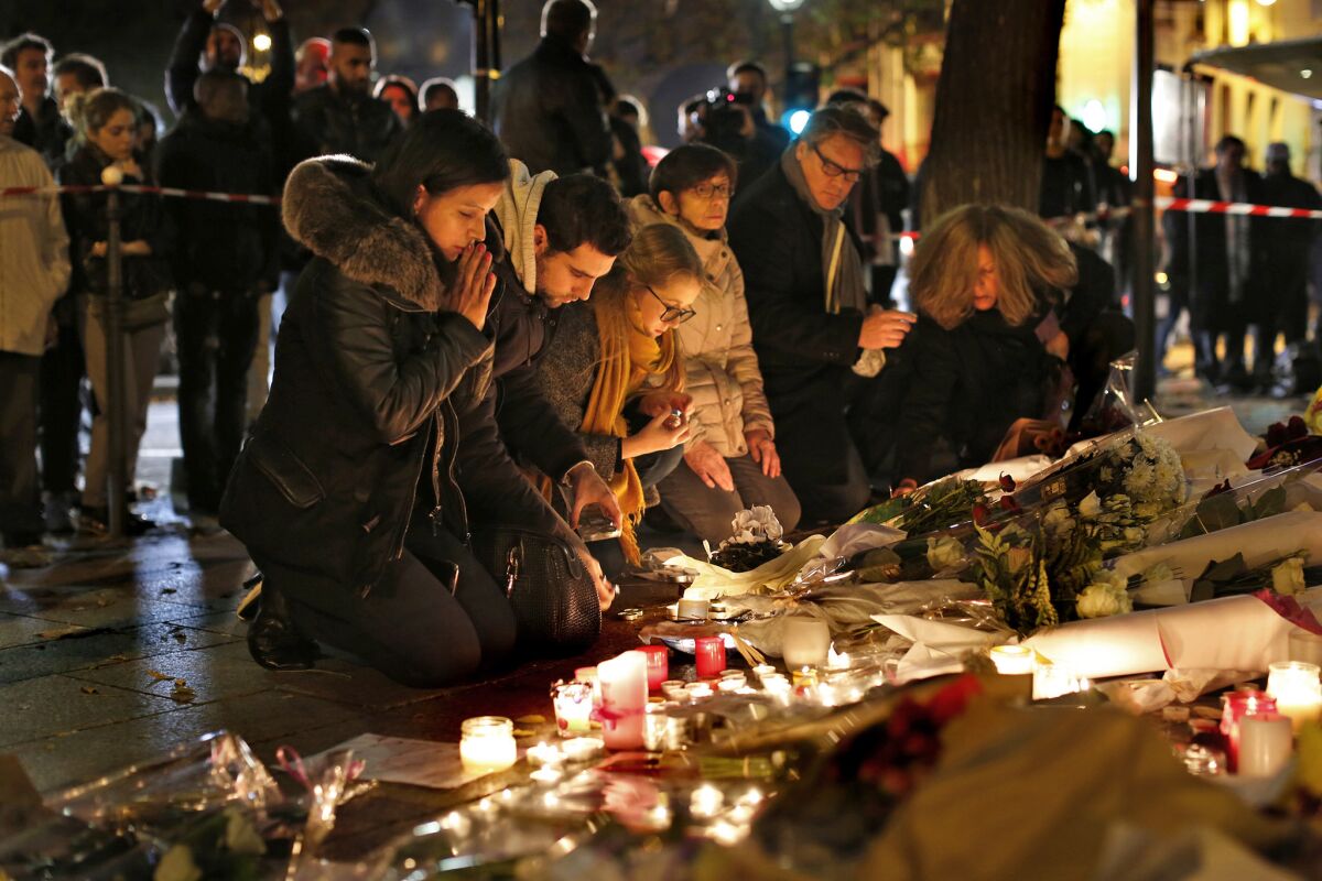 Mourners place flowers and candles outside the Bataclan theater in Paris.