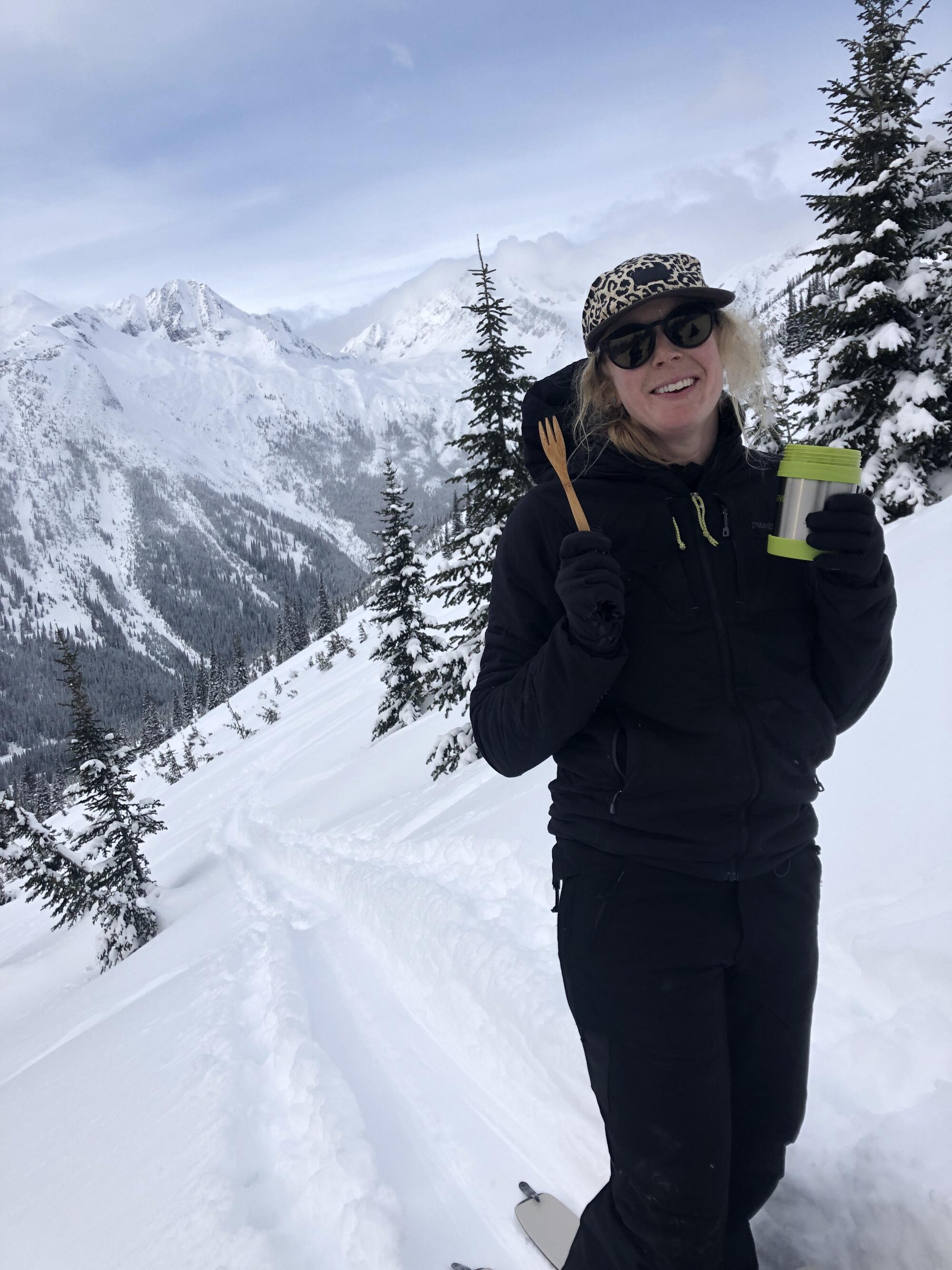 A woman smiles on a snowy mountain slope