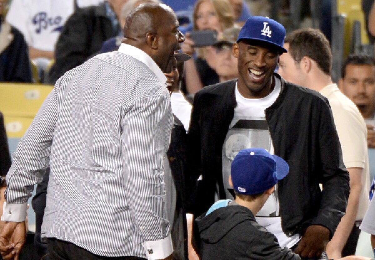 Lakers legend Magic Johnson and All-Star guard Kobe Bryant share a laugh during a Dodgers game last season.