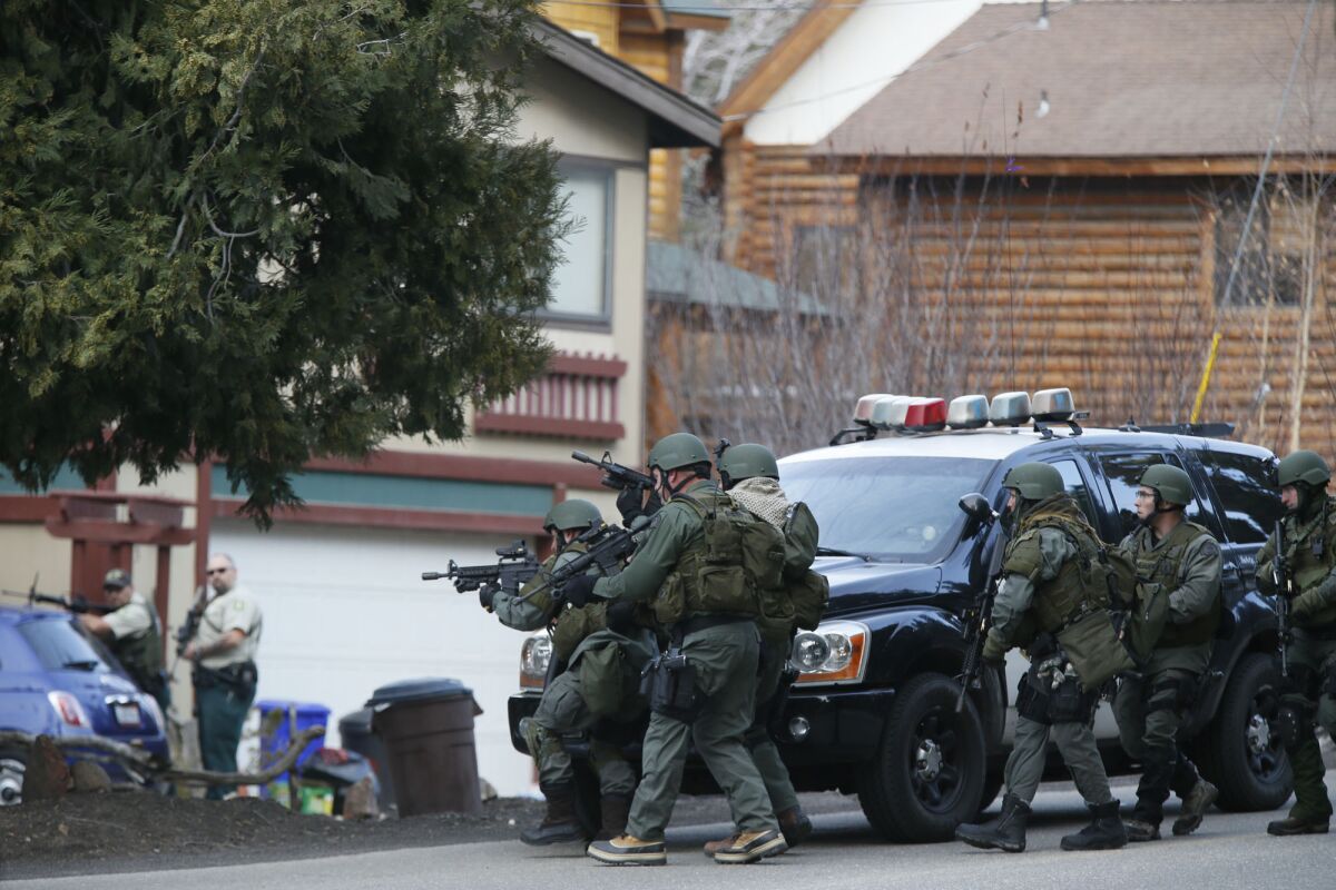 A SWAT team enters a home in Big Bear during the search for Christopher Dorner. Law enforcement agencies swarmed the mountain community after the suspect's burned truck was found on a remote road.