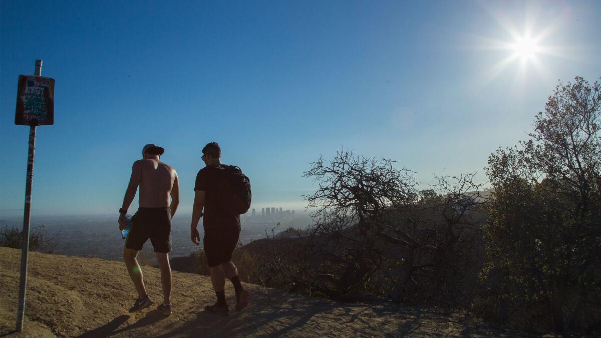 Hikers walk along a rugged trail that is under a red flag warning through Friday night as forecasters warn of dry, gusty winds moving through Southern California.