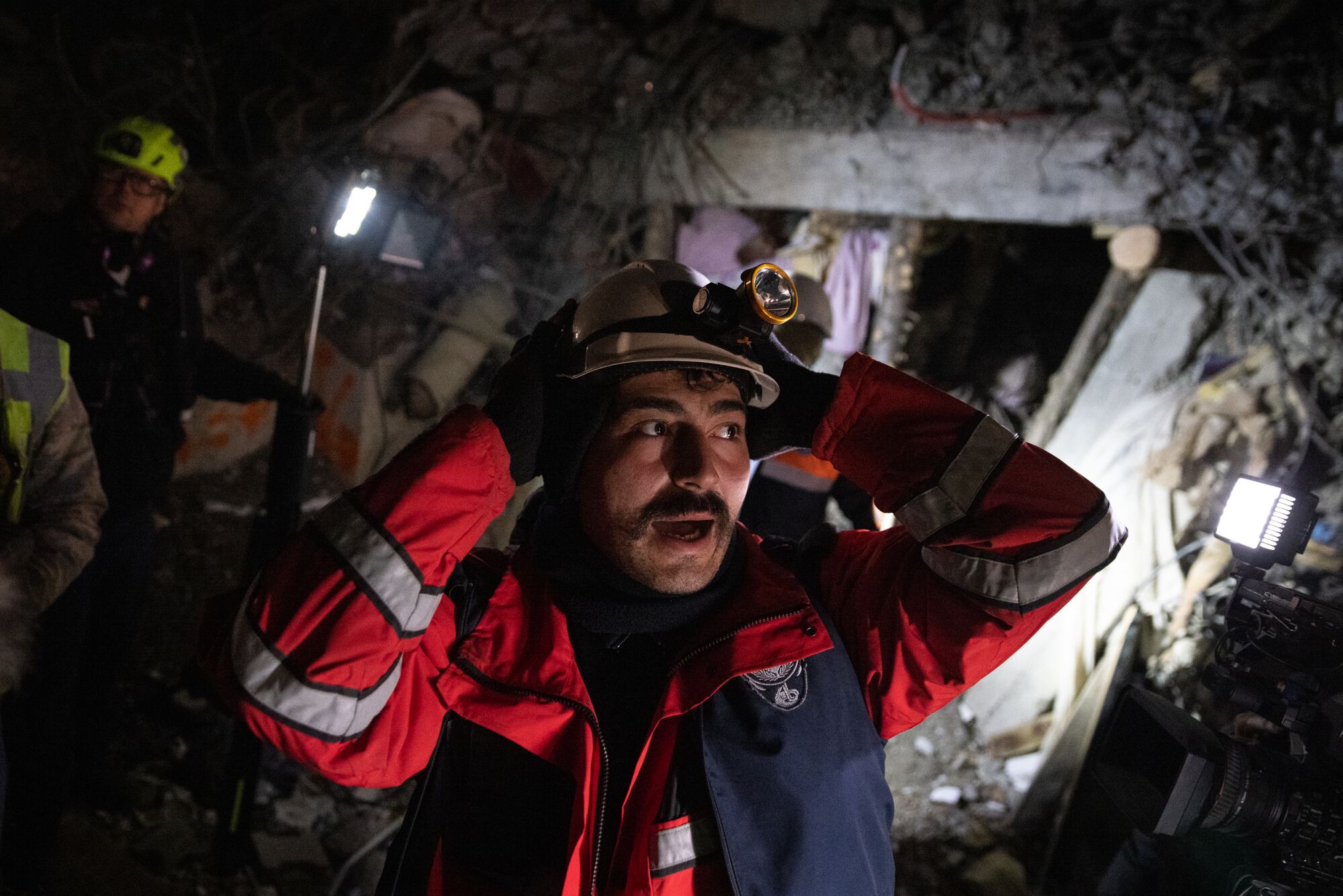 A man opens his mouth and holds his helmet