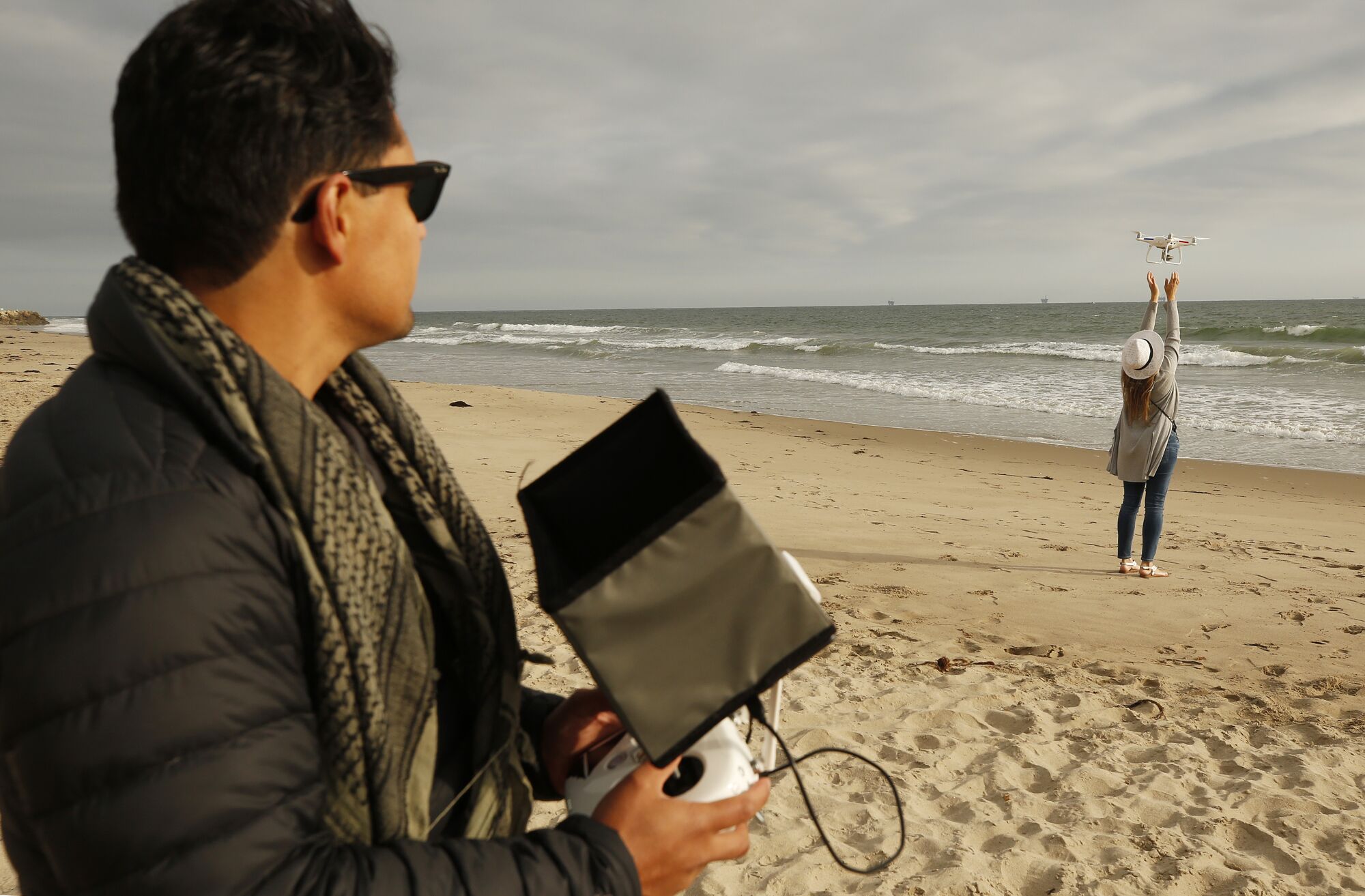 Drone photographer Carlos Gauna, with the assistance from his wife, Andressa, launches a drone