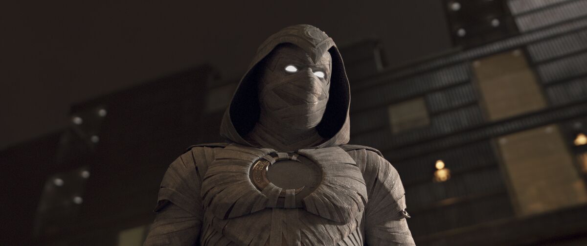 A masked superhero with glowing eyes in a hooded cloak.