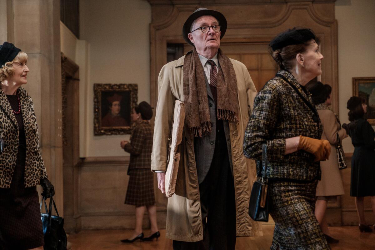Jim Broadbent stands in the middle of an art gallery in a scene from "The Duke."