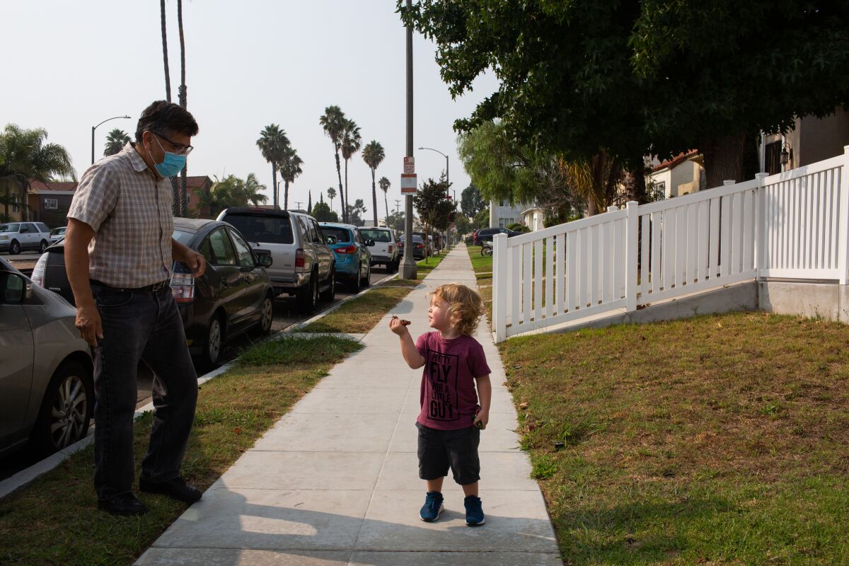 Milo Walker, with his grandfather, stands on a sidewalk in Torrance.