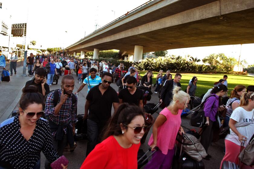 After hours of waiting, travelers stream back into LAX to make their flights, which had been delayed when a gunman began shooting inside the airport Nov. 1.