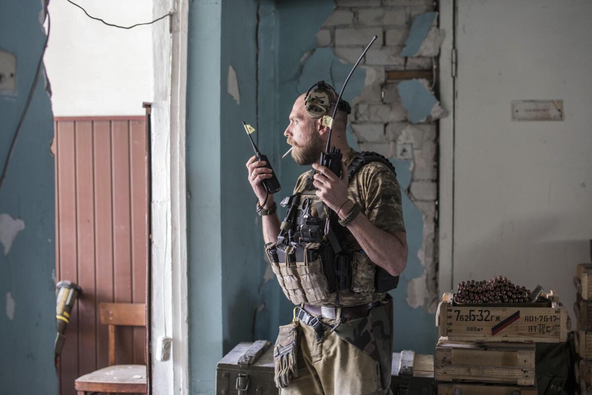 A Ukrainian soldier holds radios during heavy fighting on the front line in Severodonetsk, the Luhansk region, Ukraine, Wednesday, June 8, 2022. (AP Photo/Oleksandr Ratushniak)