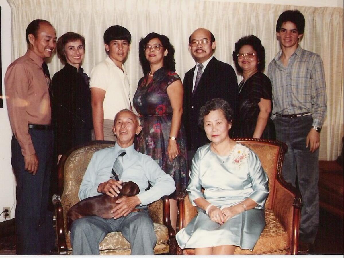 A Chinese couple are seated with relatives standing behind them