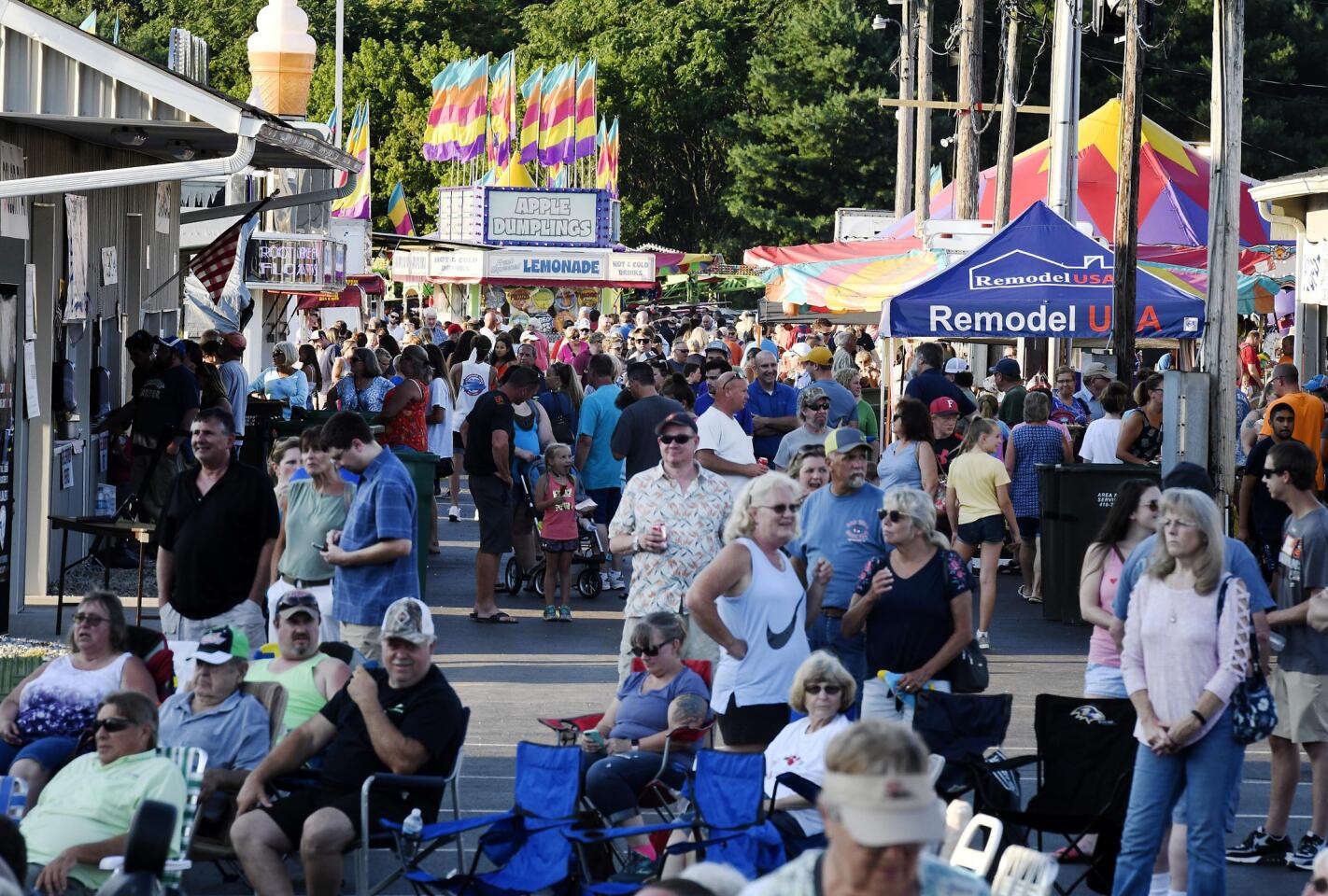 Carnival-goers begin to fill the midway of the Winfield fire company carnival Wednesday, July 10, 2019.