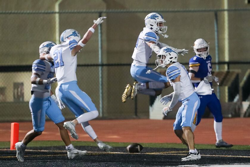 Corona del Mar's Oliver Ayala (5) far right, celebrates a touchdown after a punt return during Sunset League football opener against Fountain Valley on Friday.