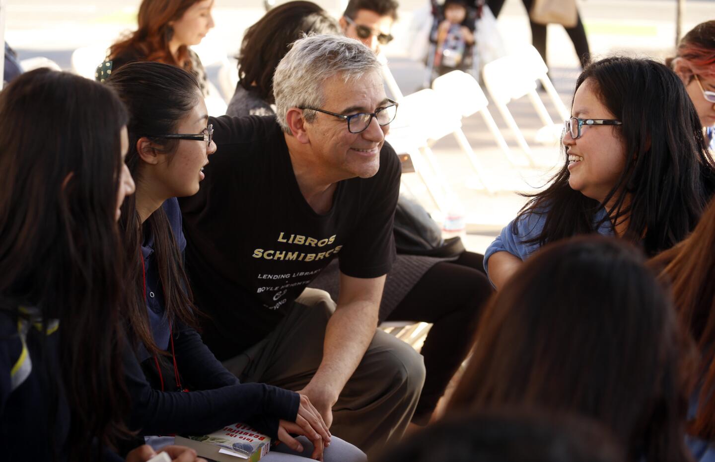 David Kipen, co-director of Libros Schmibros, center, chats with Mendez High School librarian Kim Leng, right, and members of the Mendez Reading club at Mariachi Plaza in Boyle Heights.