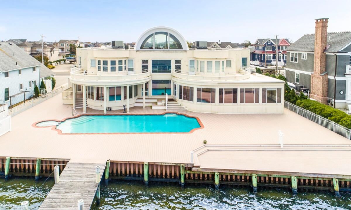 The cream-colored waterfront home opens to a private dock overlooking Barnegat Bay.
