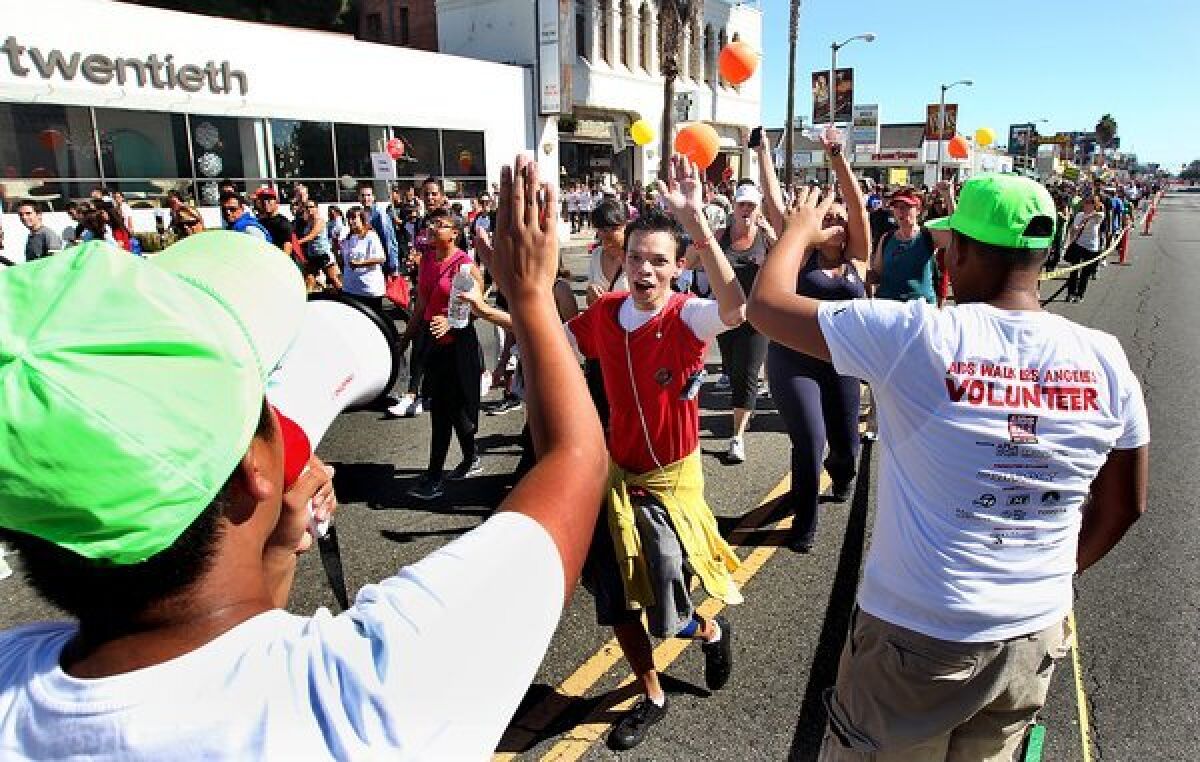 Volunteers at last year's AIDS Walk Los Angeles cheer on participants on Beverly Boulevard, including Matthew Paulson of Riverside, center.