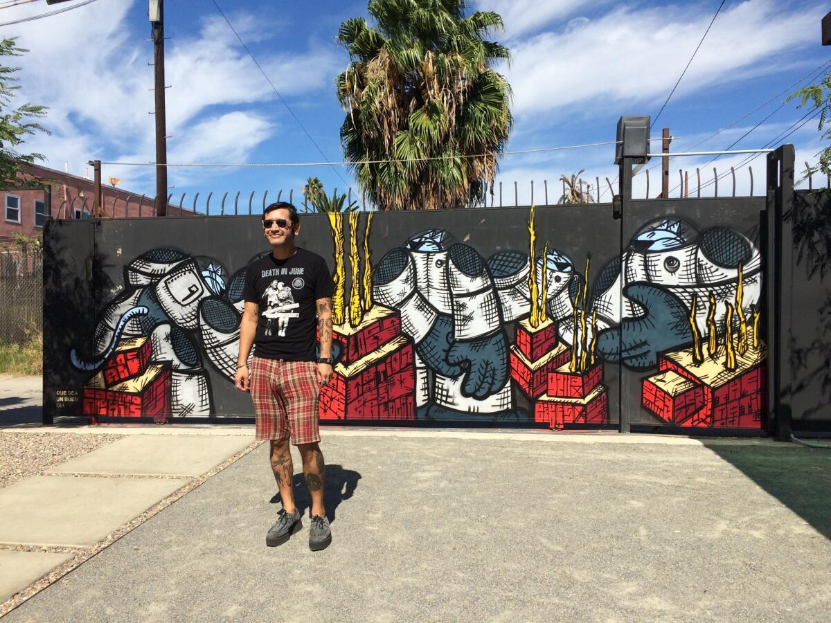 Gerardo Yepiz, known as Acamonchi, stands before a mural he painted at the Gold Leaf Gallery in San Diego. Though Yepiz has lived in the U.S. for almost two decades, he is intimately associated with Tijuana's art scene.