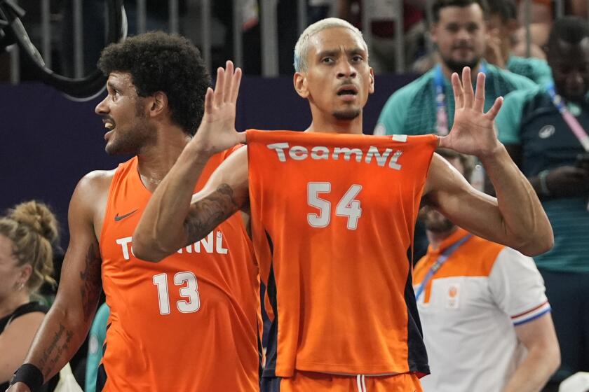 Dimeo van der Horst (13) y Worthy de Jong (54), de Holanda, celebran la victoria de su equipo 18-17 en tiempo extra frente a Francia, después de ganar la medalla de oro en el baloncesto masculino 3x3 de los Juegos Olímpicos de París, el lunes 5 de agosto de 2024, en París, Francia. (AP Foto/Frank Franklin II)