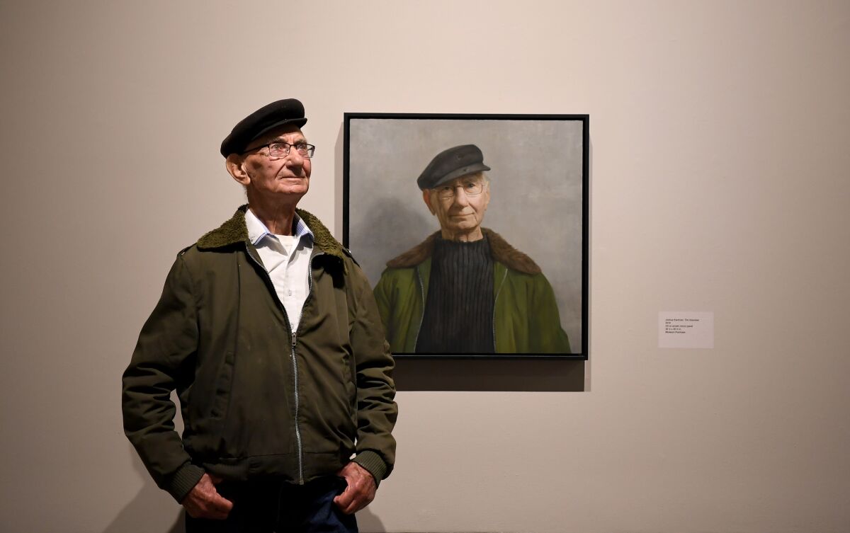 Holocaust survivor Joshua Kaufman in front of his portrait, by David Kassan, at the USC Fisher Museum of Art.  