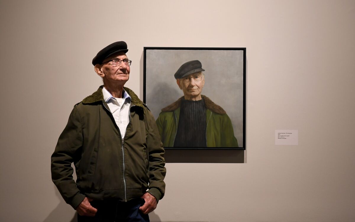 Holocaust survivor Joshua Kaufman in front of his portrait, by David Kassan, at the USC Fisher Museum of Art.