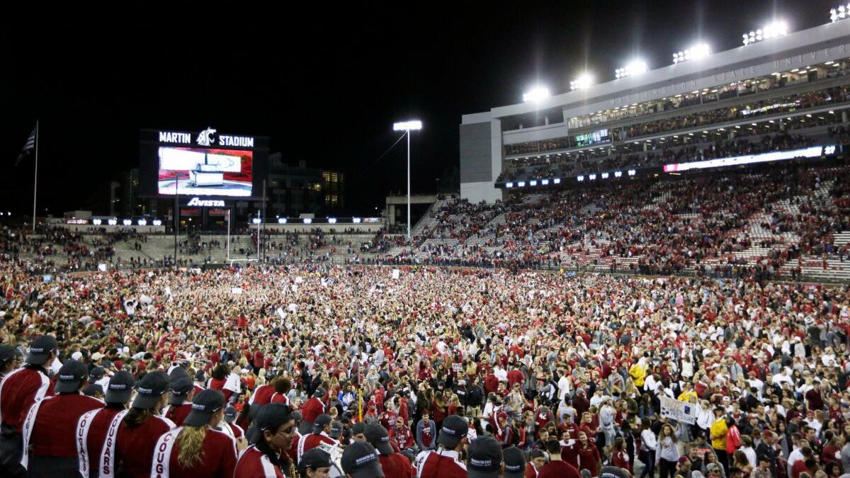 Washington State fans swarm the field after the Cougars' 30-27 victory over USC at Martin Stadium.
