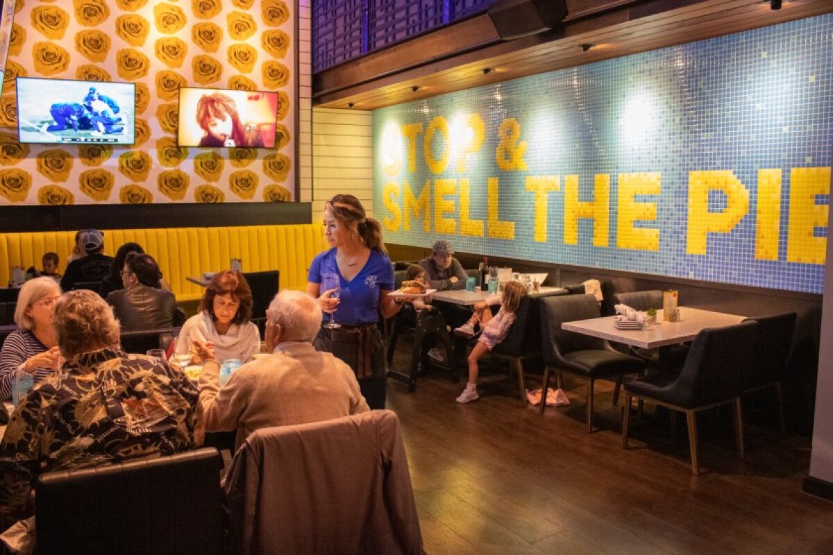 Diners try out the new menu Nov. 7 at Cohn Restaurant Group’s just-unveiled Pacific Social in Carmel Valley. The Italian-made tile wall mural highlights the new American restaurant’s cream and baked fruit pies, which are made in-house daily.