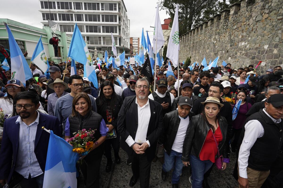 El presidente electo Bernardo Arévalo, en el centro, encabeza una marcha en protesta por la interferencia judicial