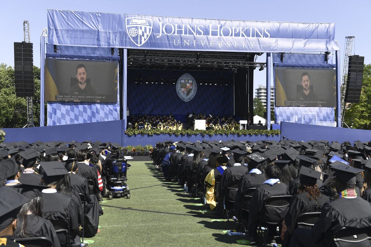 Ukraine's president on screen addressing Johns Hopkins graduation ceremony