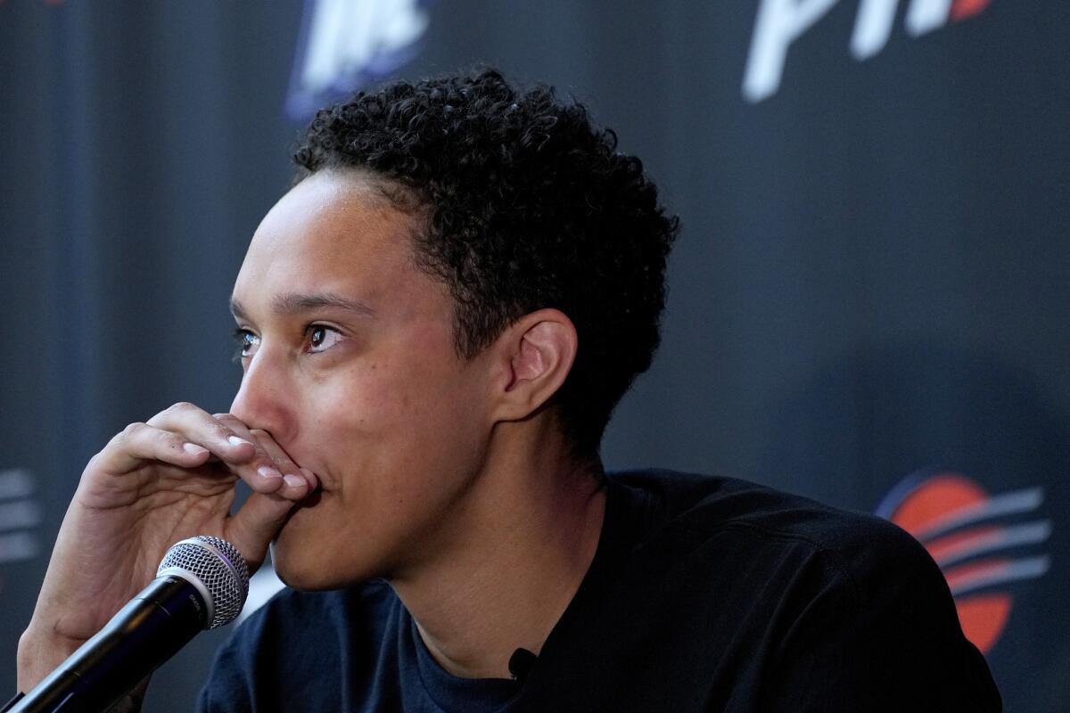 WNBA basketball player Brittney Griner fights back tears at a news conference.