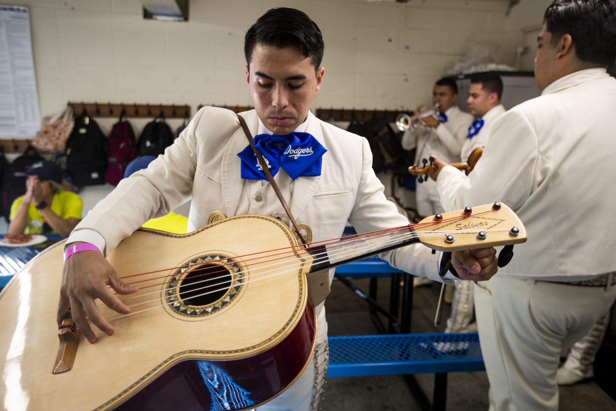 Le guitariste de Mariachi Garibaldi de Jaime Cuellar, Albert Jimenez, accorde son guitarron sous les gradins.