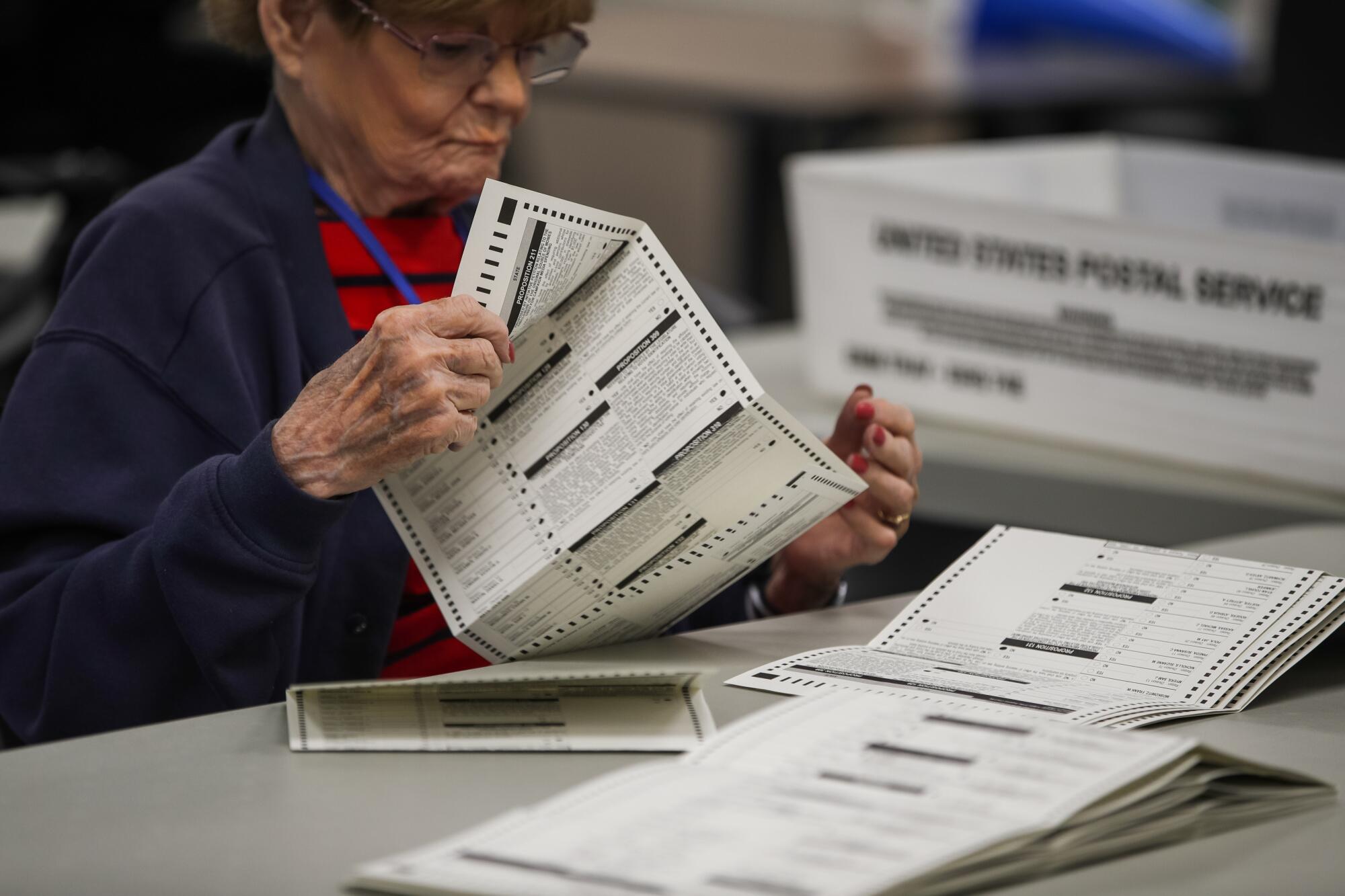 An election worker looks over ballots in Phoenix.