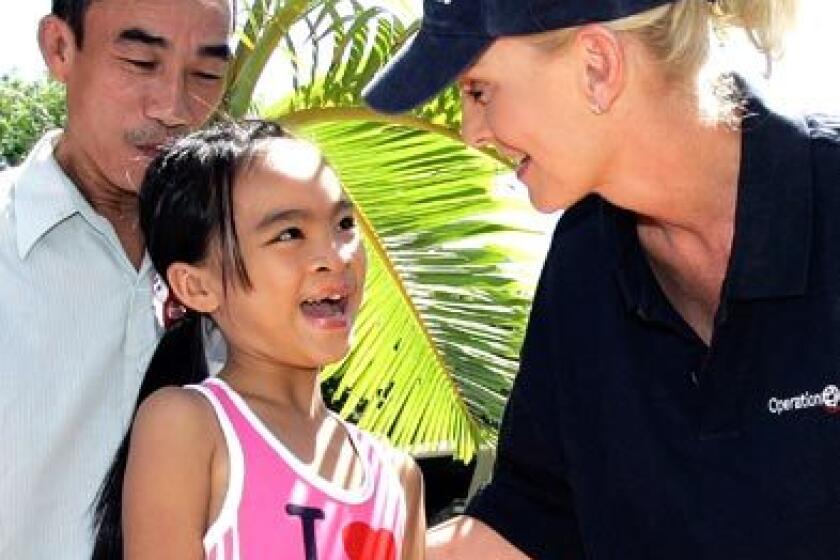 Cindy McCain, wife of Arizona Sen. John McCain, the presumptive Republican presidential candidate, meets with Phuoc Thi Le, 11, during a visit to an Operation Smile mission in Nha Trang,Vietnam, earlier this month. In 1997, the McCains arranged for Le, who was born with a facial deformity, to be brought to the U.S. for surgery. Le's father, Le Van Tan, looks on at their reunion.