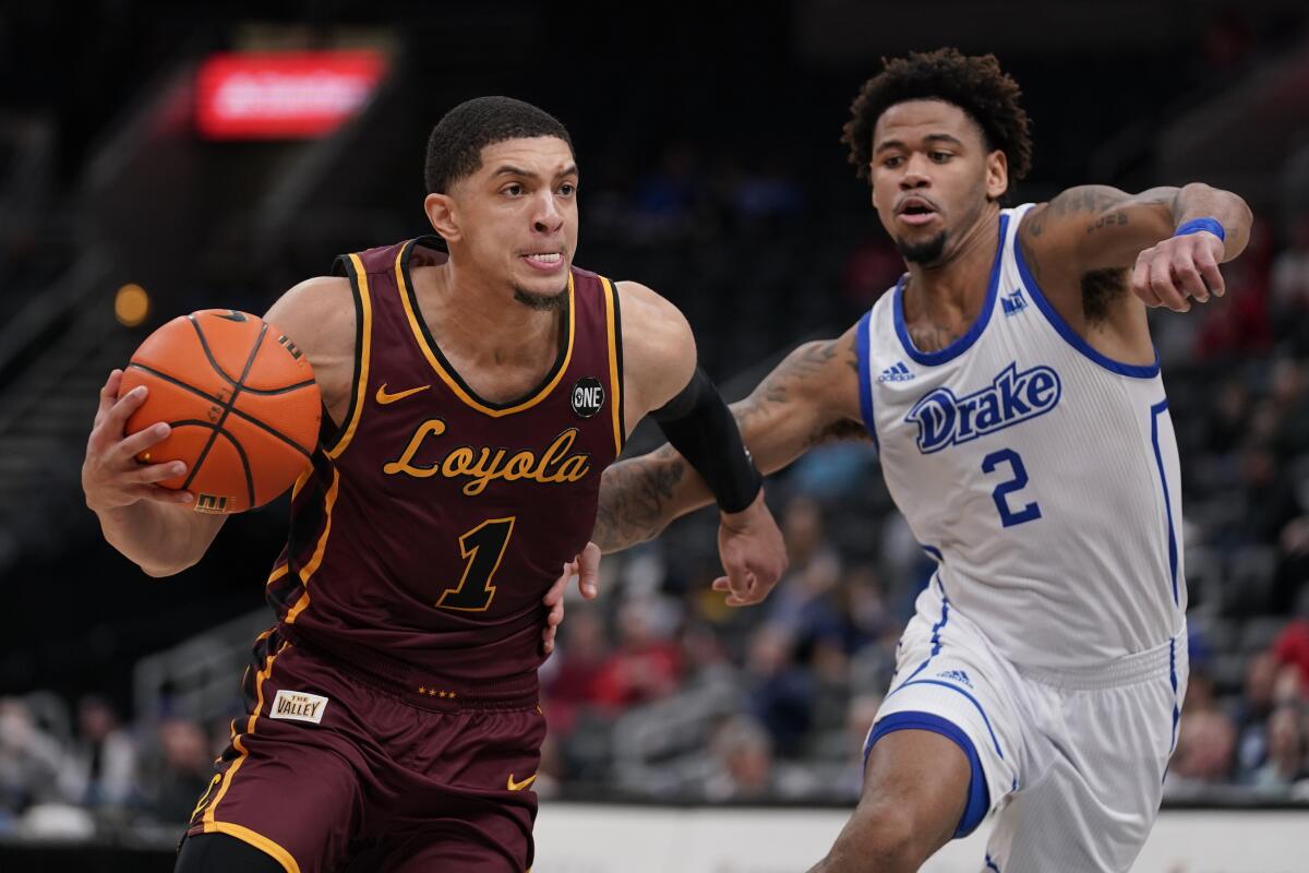 Loyola Chicago's Lucas Williamson heads to the basket as Drake's Tremell Murphy defends.