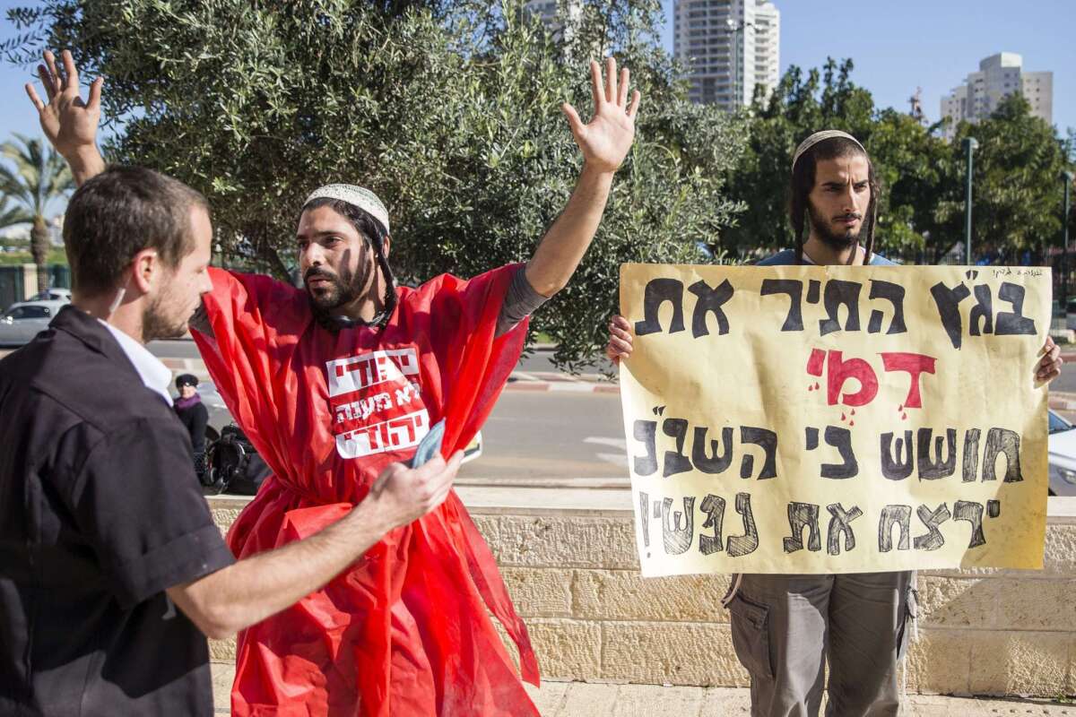 An Israeli right-wing activist holds a placard in front of the Justice Court in Petah Tikva, Israel, during a protest against interrogation methods they say are used by the Israeli intelligence services to interrogate suspected Jewish extremists.