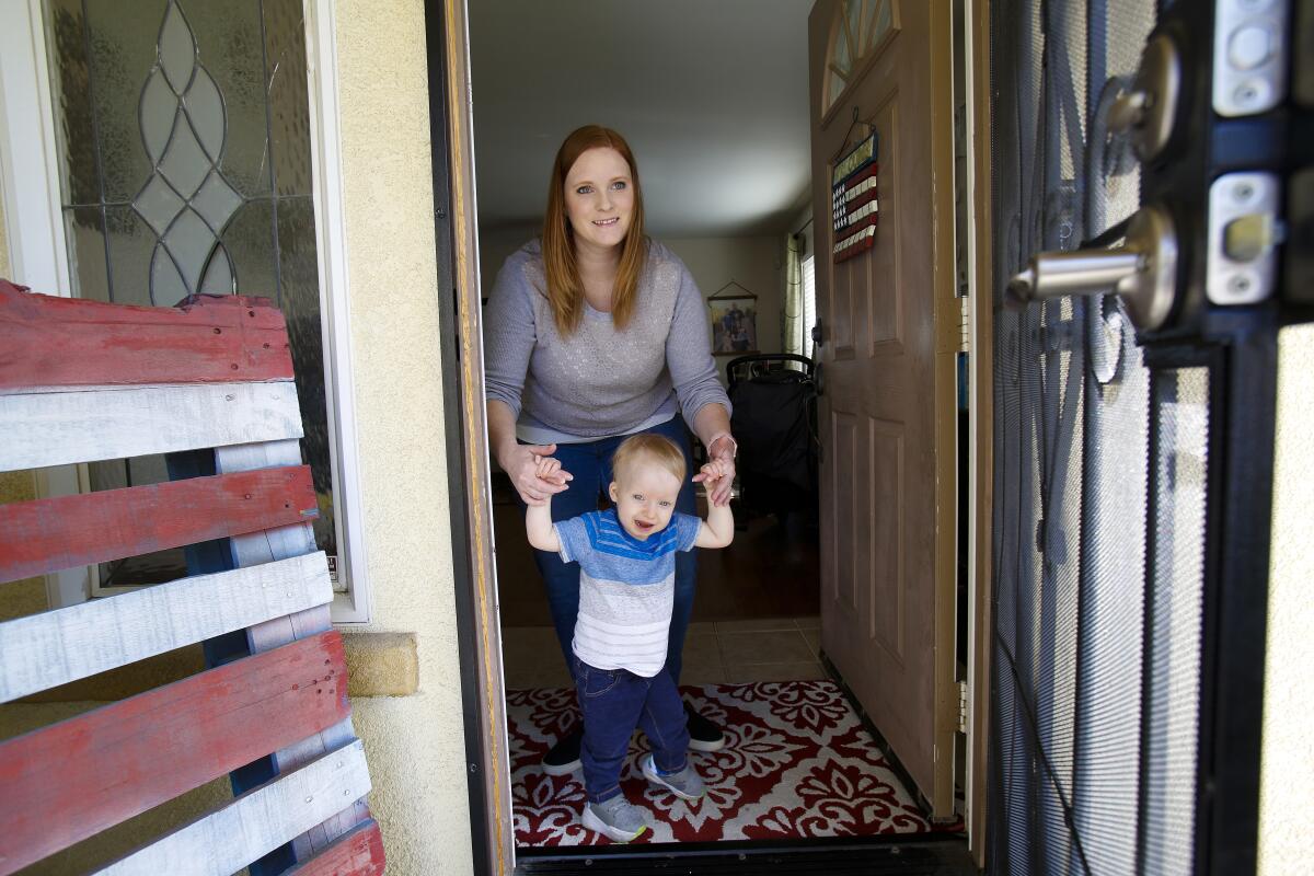 Charlie Luckesen, with help from his mother Katie Luckesen, walking to the front door of the family's home in South San Diego.