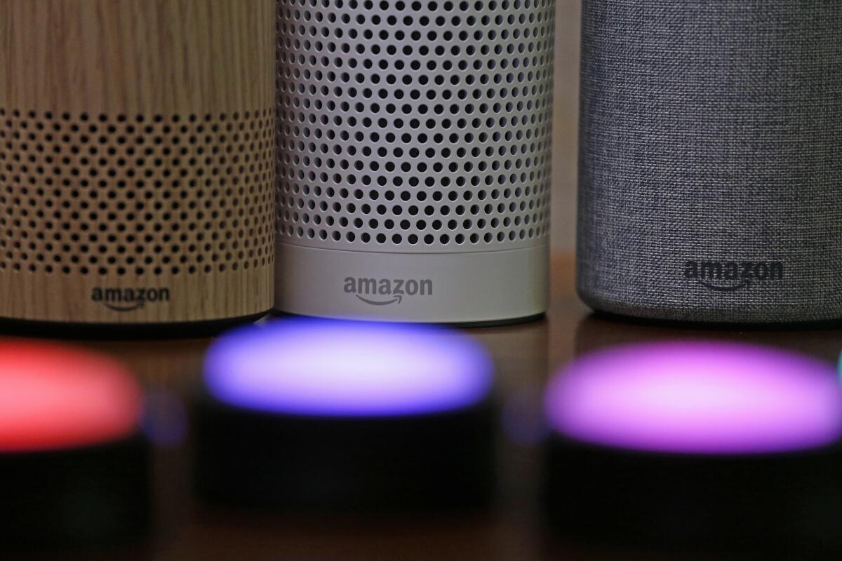 Three Amazon Echo devices sit behind illuminated Echo Button devices 