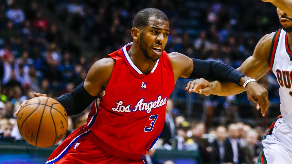 Clippers point guard Chris Paul, left, tries to drive past Milwaukee Bucks guard Jerryd Bayless during the Clippers' 111-106 road loss on Dec. 13.